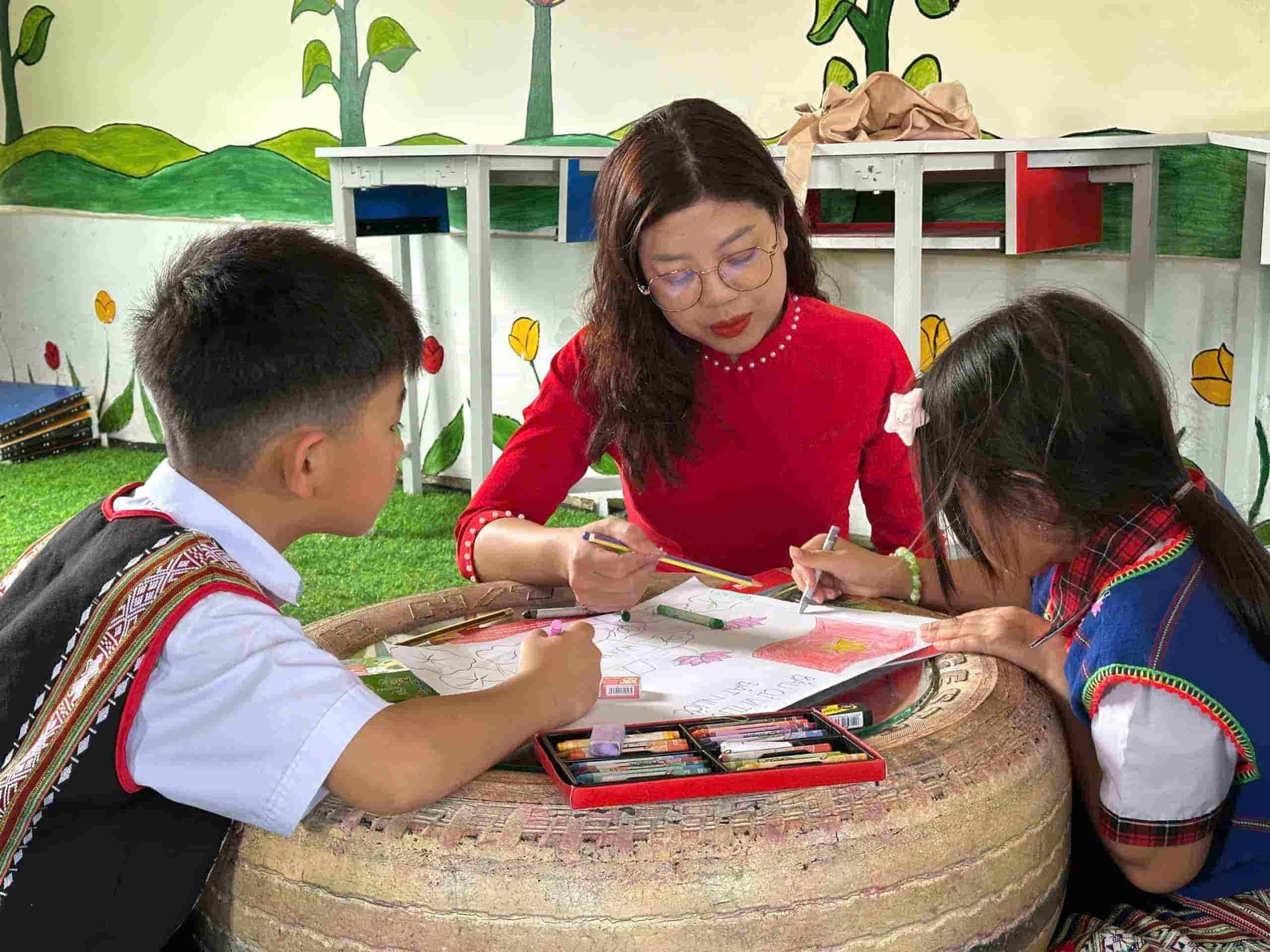 Giáo viên hướng dẫn các em học sinh vẽ tranh cổ động. Ảnh: Mạnh Võ